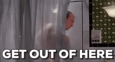 A Man Is Taking A Shower In A Bathroom With The Words `` Get Out Of Here '' Written Above Him . GIF