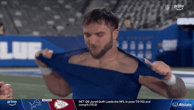 A Man Is Taking Off His Shirt While Watching A Football Game On Prime GIF