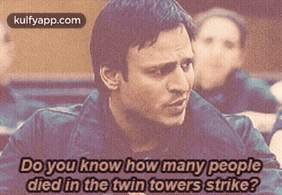 A Man Is Talking About How Many People Died In A Twin Towers Strike . GIF