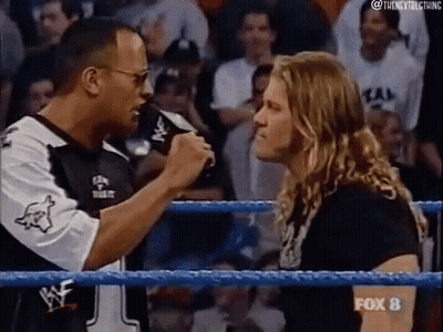 A Man Is Talking Into A Microphone In A Wrestling Ring . GIF