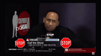 A Man Is Talking Into A Microphone While A Stop Sign Is In Front Of Him GIF
