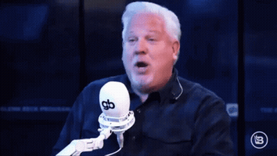 A Man Is Talking Into A Microphone With The Words Doinks Written In Front Of Him GIF
