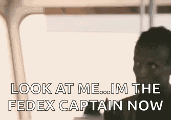 A Man Is Talking On A Cell Phone And Looking At The Fedex Captain Now . GIF