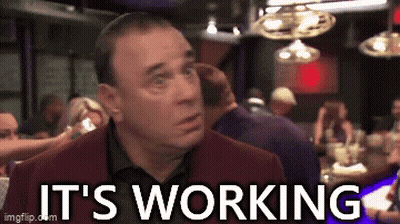 A Man Is Talking On A Cell Phone In A Bar And The Words It 'S Working Are Visible . GIF