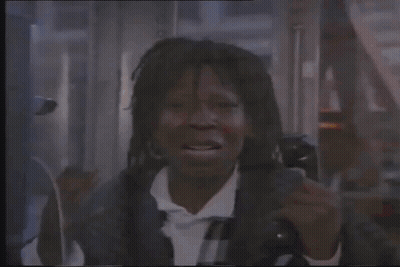 A Man Is Talking On A Cell Phone In A Phone Booth . GIF