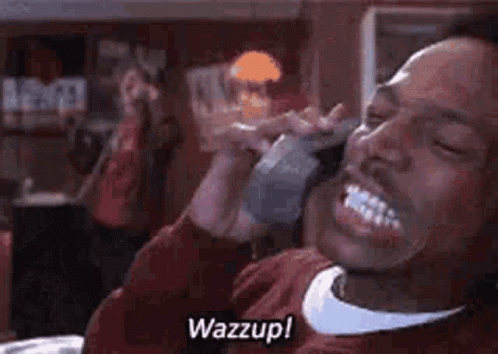 A Man Is Talking On A Cell Phone In A Restaurant While Smiling . GIF
