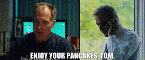 A Man Is Talking On A Cell Phone Next To Another Man Who Says Enjoy Your Pancakes , Tom . GIF