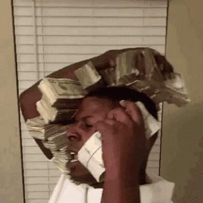 A Man Is Talking On A Cell Phone While Carrying A Stack Of Money On His Head . GIF