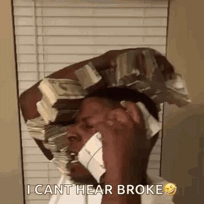 A Man Is Talking On A Cell Phone While Holding A Stack Of Money On His Head . GIF
