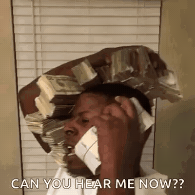 A Man Is Talking On A Cell Phone While Holding A Stack Of Money On His Head . GIF