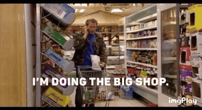 A Man Is Talking On A Cell Phone While Pushing A Shopping Cart In A Grocery Store . GIF