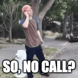 A Man Is Talking On A Cell Phone While Walking Down A Sidewalk . GIF