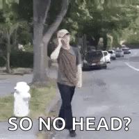 A Man Is Talking On A Cell Phone While Walking Down A Street . GIF