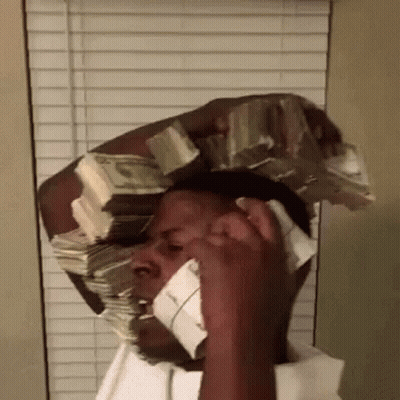 A Man Is Talking On A Cell Phone With A Large Stack Of Money On His Head . GIF