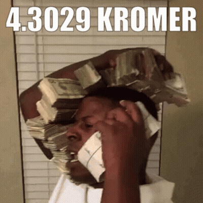 A Man Is Talking On A Cell Phone With A Stack Of Money On His Head GIF