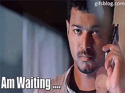 A Man Is Talking On A Cell Phone With The Words `` Am Waiting '' Written On The Bottom . GIF