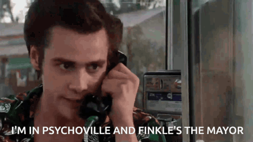 A Man Is Talking On A Pay Phone And Says `` I 'M In Psychoville And Finkle 'S The Mayor '' GIF