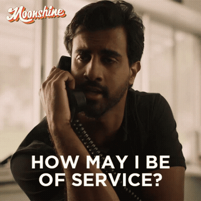 A Man Is Talking On A Phone With The Words How May I Be Of Service GIF