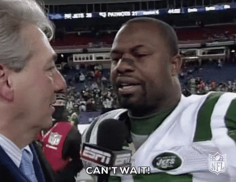 A Man Is Talking To A Football Player Who Is Wearing A Jersey That Says Jets . GIF
