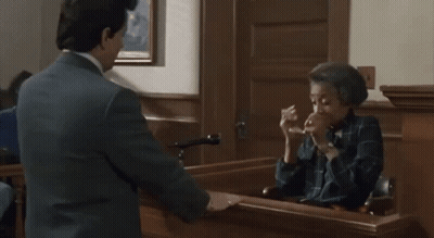 A Man Is Talking To A Woman In A Courtroom . GIF