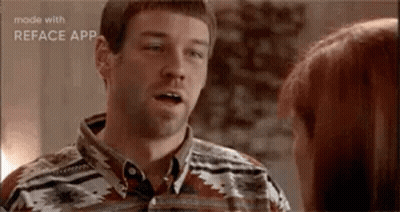 A Man Is Talking To A Woman In A Room . GIF