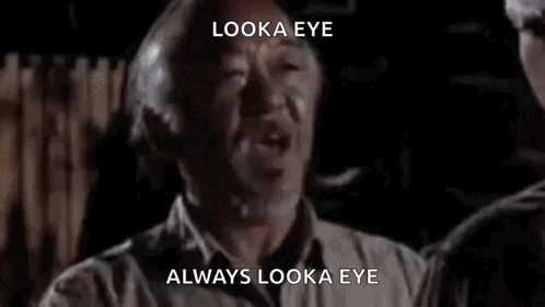 A Man Is Talking To Another Man In A Dark Room And Says `` Look A Eye , Always Look A Eye '' . GIF