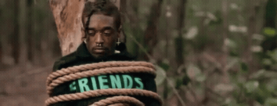 A Man Is Tied To A Tree Trunk With A Rope . GIF