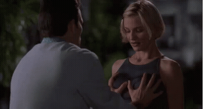 A Man Is Touching A Woman 'S Breast While Standing Next To Her . GIF