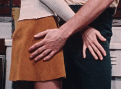 A Man Is Touching A Woman 'S Butt With His Hand GIF
