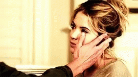 A Man Is Touching A Woman 'S Face In A Room . GIF