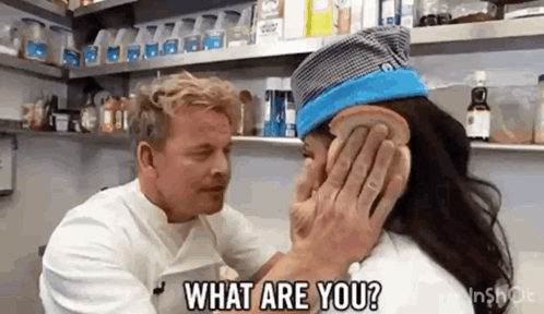 A Man Is Touching A Woman 'S Face With A Piece Of Bread . GIF