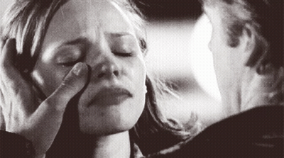 A Man Is Touching A Woman 'S Face With His Hand . GIF