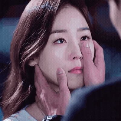 A Man Is Touching A Woman 'S Face With His Hands GIF