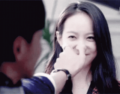 A Man Is Touching A Woman 'S Nose While She Smiles GIF