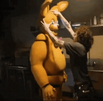 A Man Is Touching The Face Of A Stuffed Animal GIF