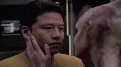 A Man Is Touching The Face Of Another Man GIF