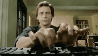 A Man Is Typing On A Computer Keyboard While Sitting At A Table . GIF