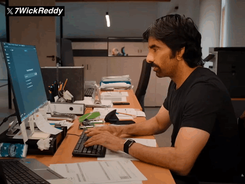 A Man Is Typing On A Keyboard In Front Of A Computer And A Sign That Says X7wick Reddy GIF