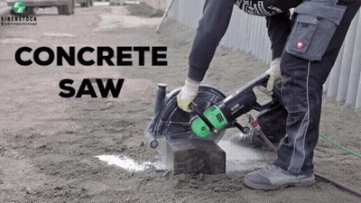 A Man Is Using A Concrete Saw To Cut A Concrete Block GIF