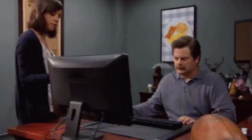 A Man Is Using A Dell Computer While A Woman Stands Behind Him GIF