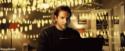 A Man Is Using A Laptop In Front Of A Wall That Says ' I Love You ' GIF