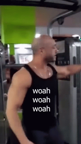A Man Is Using A Machine In A Gym With The Words Woah Woah Woah Written On His Shirt . GIF