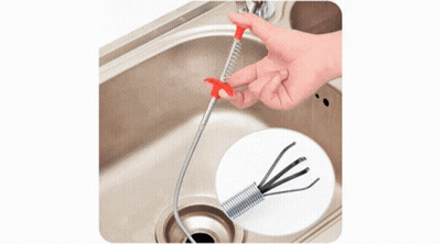 A Man Is Using A Milwaukee Drain Cleaner To Clear A Drain Under A Sink GIF