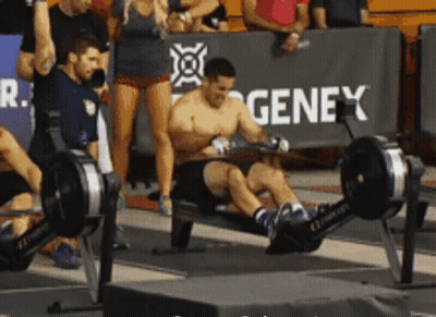 A Man Is Using A Rowing Machine In Front Of A Genex Sign GIF