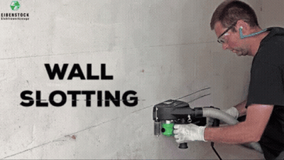A Man Is Using A Wall Slotting Machine To Cut Holes In A Wall GIF