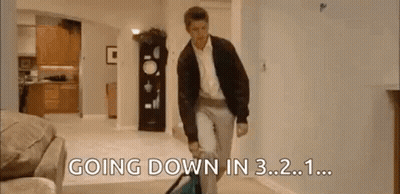 A Man Is Walking Down A Hallway In A Living Room With The Words `` Going Down In 3.2 . '' GIF