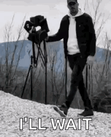A Man Is Walking Down A Hill With A Camera In His Hand . GIF