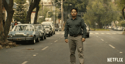 A Man Is Walking Down A Street With A Netflix Logo In The Corner GIF