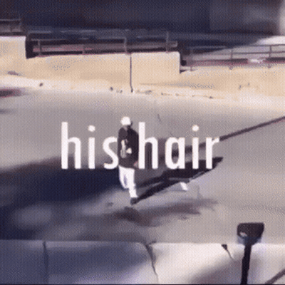 A Man Is Walking Down A Street With The Words His Hair Written Above Him GIF