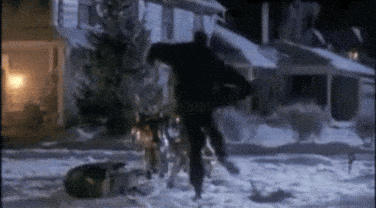A Man Is Walking In The Snow With A Dog . GIF